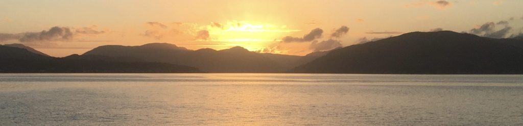 Sunset over the sea with hills of Argyll silhouetted on the horizon